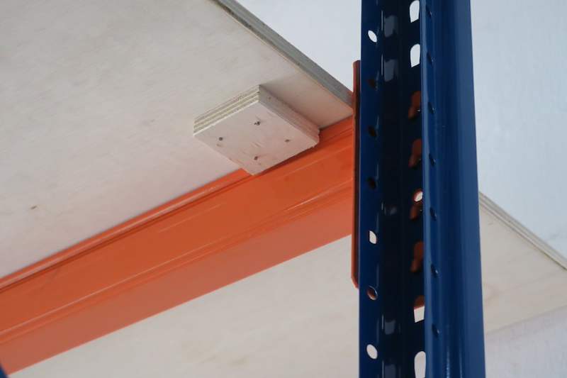 Close view of an orange beam connector locked into a blue upright with plywood decking above - V3000 Racking - V3-2 | Wong Lye Racking, Singapore Racking Manufacturer