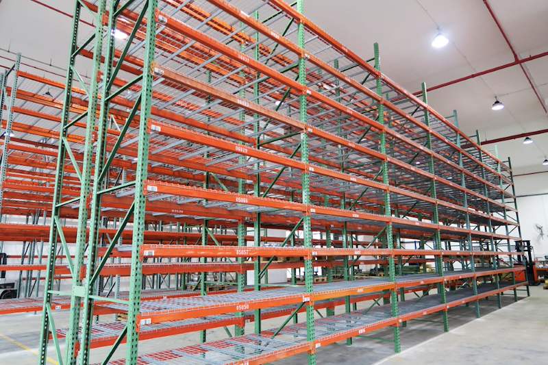 Tall pallet racking runs with mesh decking, forklift at the far end of the aisle - V3000 Racking - V3-3 | Wong Lye Racking, Singapore Racking Manufacturer
