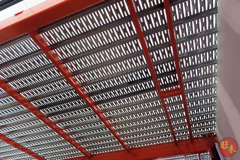 Underside of the mezzanine floor showing red beams and grey perforated steel decking panels - V6000 Racking - V6-7 | Wong Lye Racking, Singapore Racking Manufacturer