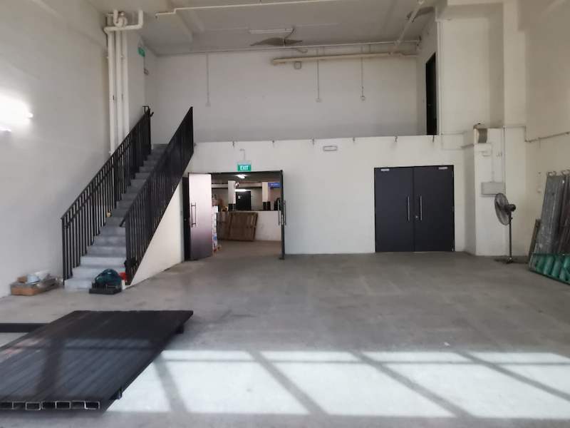 Empty unit with the mezzanine staircase in the corner and deck panels on the floor, installation in progress - V5000 Racking - V5-9 | Wong Lye Racking, Singapore Racking Manufacturer