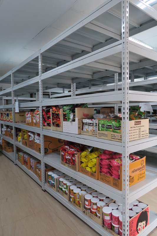 Bagged snacks and canned goods on a grey boltless shelving bay, viewed from the end - Boltless Racking - B2 | Wong Lye Racking, Singapore Racking Manufacturer