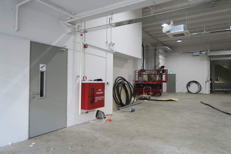 Before: door and fire hose reel cabinet in the empty unit, scissor lift beyond - Boltless Racking - B8 | Wong Lye Racking, Singapore Racking Manufacturer