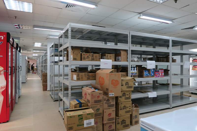 Rows of boltless shelving with cartons on the shelves, glass-door chillers along the wall - Boltless Racking - B2 | Wong Lye Racking, Singapore Racking Manufacturer