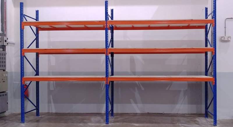 Two bays of V3000 racking with three orange beam levels and plywood decking against a workshop wall - V3000 Racking - V3-1 | Wong Lye Racking, Singapore Racking Manufacturer