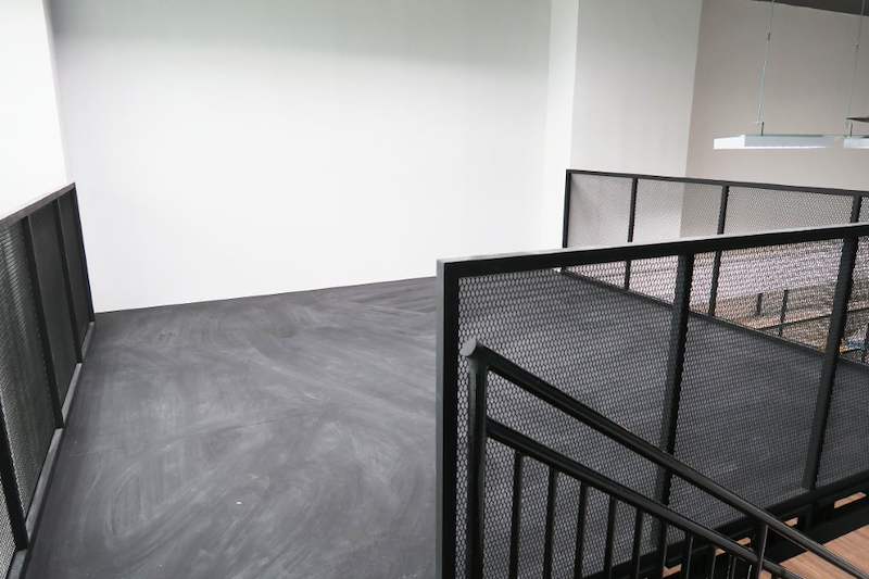 Upper mezzanine deck with black mesh railing and stair landing, floor empty - V5000 Racking - V5-16 | Wong Lye Racking, Singapore Racking Manufacturer
