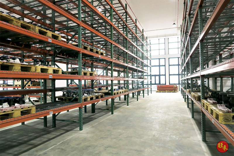 Aisle between loaded pallet racking runs, pallets of goods on the lower levels and windows at the end - V3000 Racking - V3-3 | Wong Lye Racking, Singapore Racking Manufacturer