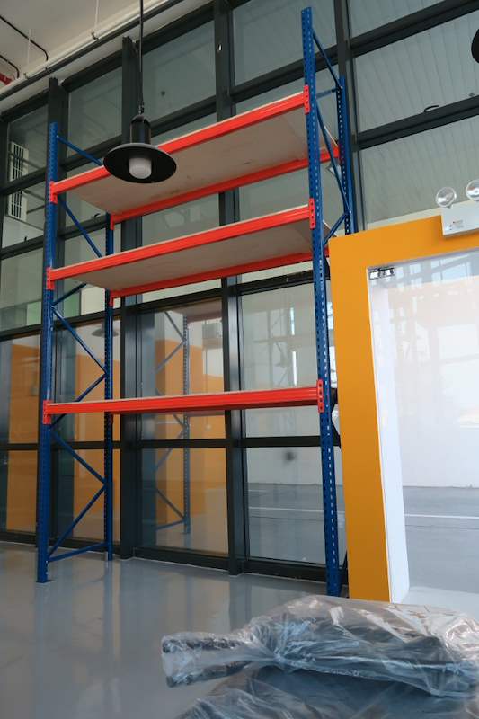 Empty V3000 racking bay with three plywood levels beside a glass partition - V3000 Racking - V3-4 | Wong Lye Racking, Singapore Racking Manufacturer