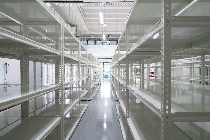 Aisle of white boltless shelving leading to the store entrance - Boltless Racking - B8 | Wong Lye Racking, Singapore Racking Manufacturer