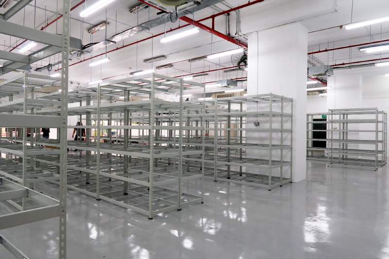 After: rows of beige boltless shelving installed across the unit on the finished epoxy floor - Boltless Racking - B7 | Wong Lye Racking, Singapore Racking Manufacturer