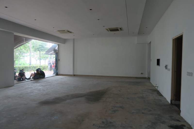 Before: empty ground-floor unit with bare concrete floor and glass frontage before the shelving was installed - Boltless Racking - B5 | Wong Lye Racking, Singapore Racking Manufacturer