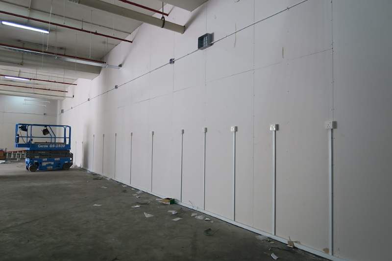 Before: new partition wall along the unit with a scissor lift, floor still bare concrete - Boltless Racking - B7 | Wong Lye Racking, Singapore Racking Manufacturer