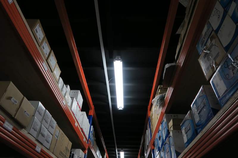 Looking up between two runs of blue-and-orange racking stacked with cartons on the mezzanine level - V5000 Racking - V5-8 | Wong Lye Racking, Singapore Racking Manufacturer