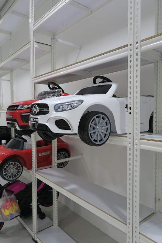 Ride-on toy cars on white boltless shelving, viewed along the run - Boltless Racking - B3 | Wong Lye Racking, Singapore Racking Manufacturer