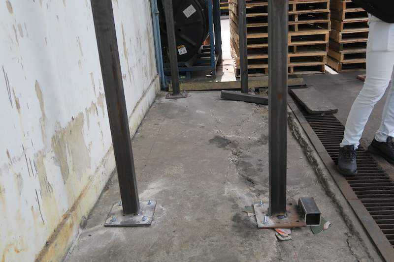 Two square-hollow steel uprights bolted to base plates on the concrete floor, beam not yet fitted - V5000 Racking - V5-1 | Wong Lye Racking, Singapore Racking Manufacturer