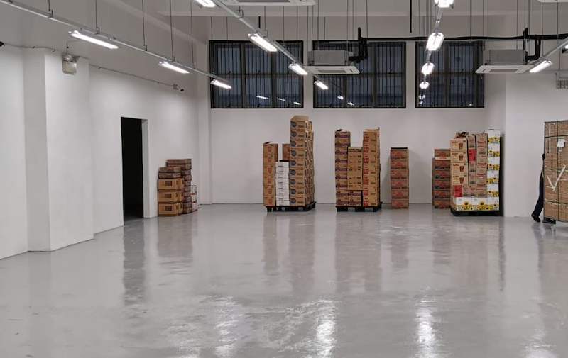 Before: empty store with an epoxy floor and pallets of cartons waiting before the shelving was installed - Boltless Racking - B1 | Wong Lye Racking, Singapore Racking Manufacturer