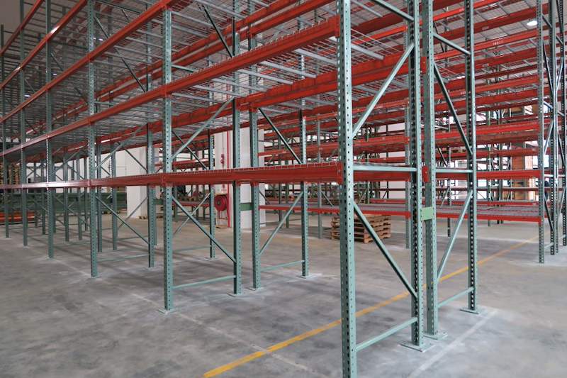 Pallet racking bays with orange beams and mesh decking along a yellow aisle line - V3000 Racking - V3-3 | Wong Lye Racking, Singapore Racking Manufacturer