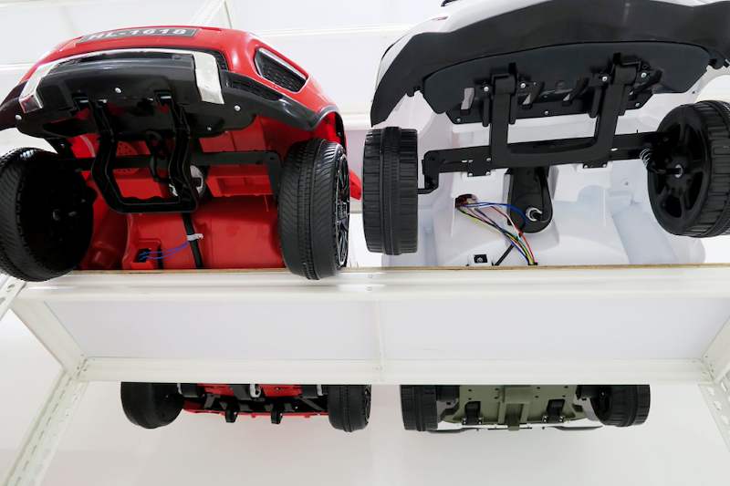 Rear view of two ride-on toy cars on a white boltless shelf, seen from below - Boltless Racking - B3 | Wong Lye Racking, Singapore Racking Manufacturer