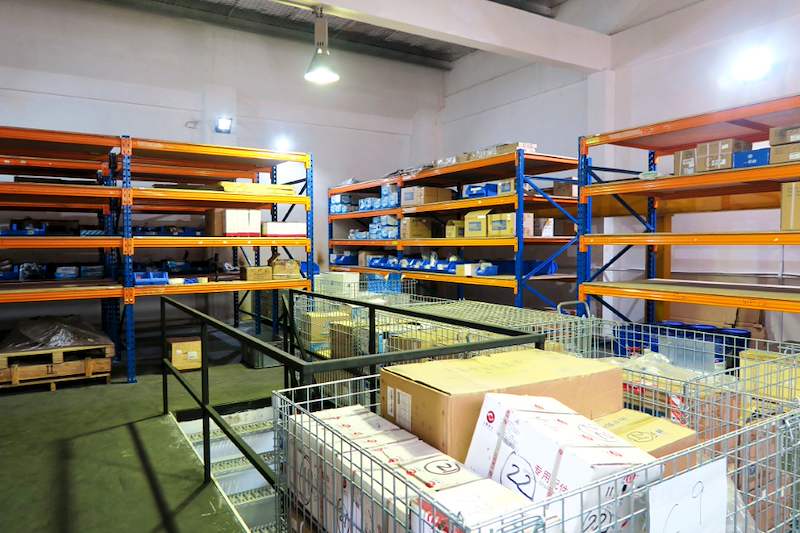 Blue-and-orange racking bays on the mezzanine deck with wire cages of cartons in the aisle - V5000 Racking - V5-8 | Wong Lye Racking, Singapore Racking Manufacturer