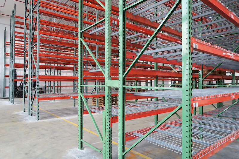Green uprights with diagonal bracing and orange beams carrying wire mesh decking, close view - V3000 Racking - V3-3 | Wong Lye Racking, Singapore Racking Manufacturer