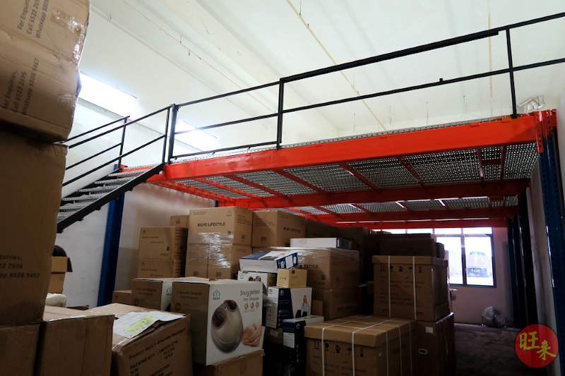 Mezzanine floor with red beams and black railing over a ground floor stacked with cartons - V6000 Racking - V6-7 | Wong Lye Racking, Singapore Racking Manufacturer