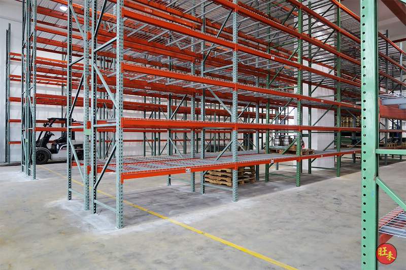 Pallet racking bays with mesh decking, forklift parked in the aisle beyond - V3000 Racking - V3-3 | Wong Lye Racking, Singapore Racking Manufacturer