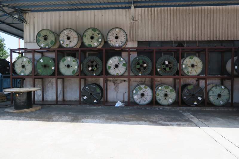 Two-tier steel cable-drum rack fully loaded with drums along an outdoor wall under a shed roof - V5000 Racking - V5-1 | Wong Lye Racking, Singapore Racking Manufacturer