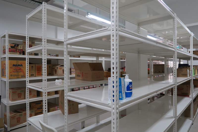 White boltless shelving units with a few cartons and bottles on the shelves, mostly empty - Boltless Racking - B6 | Wong Lye Racking, Singapore Racking Manufacturer