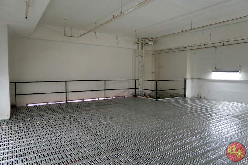 Empty upper deck of the mezzanine floor with perforated steel decking and a black railing around the edge - V6000 Racking - V6-7 | Wong Lye Racking, Singapore Racking Manufacturer
