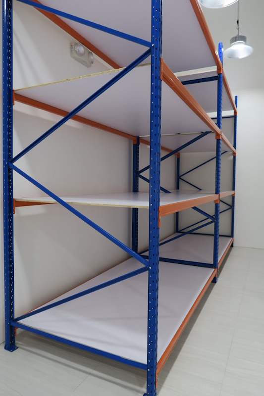Three-level long-span racking bay with blue uprights and orange beams in the corner of the room - Boltless Racking - B3 | Wong Lye Racking, Singapore Racking Manufacturer