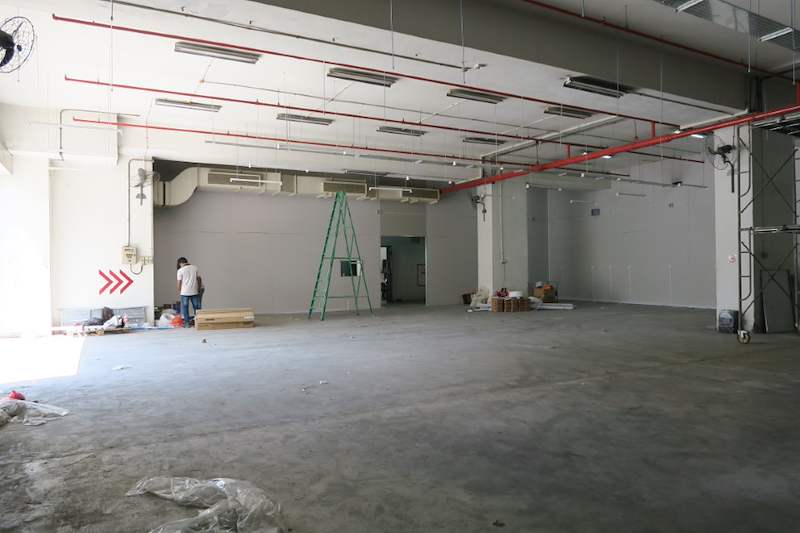 Before: bare unit with roller shutter open and a ladder on the concrete floor - Boltless Racking - B7 | Wong Lye Racking, Singapore Racking Manufacturer
