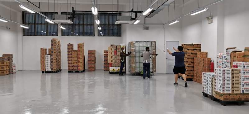 Before: workers moving pallets of cartons into the empty store before the shelving went up - Boltless Racking - B1 | Wong Lye Racking, Singapore Racking Manufacturer