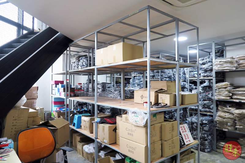Boltless shelving bays with plywood decking beside the mezzanine staircase, holding cartons, boxes and bagged garments - V8000 Racking - V8-20 | Wong Lye Racking, Singapore Racking Manufacturer