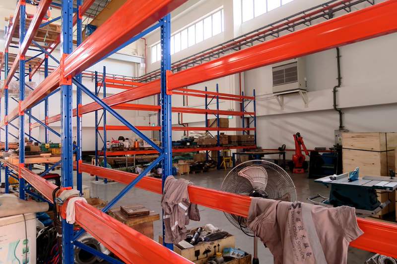 Orange beams and blue uprights of the V3000 racking with workshop tools and parts underneath - V3000 Racking - V3-5 | Wong Lye Racking, Singapore Racking Manufacturer