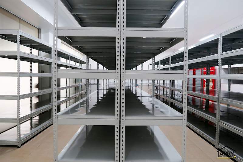 Looking down a long aisle of grey boltless shelving, shelves empty on both sides - Boltless Racking - B5 | Wong Lye Racking, Singapore Racking Manufacturer