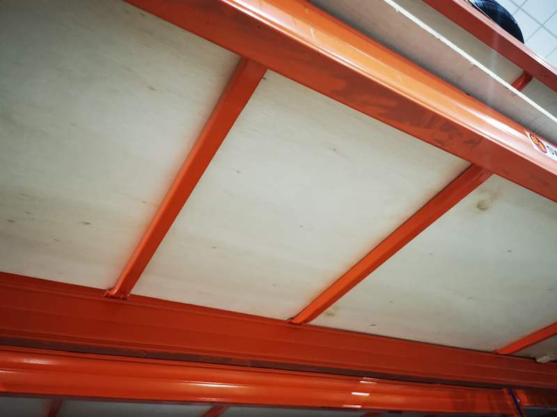 Underside of a racking level: orange beams and support bars carrying plywood decking - V3000 Racking - V3-1 | Wong Lye Racking, Singapore Racking Manufacturer