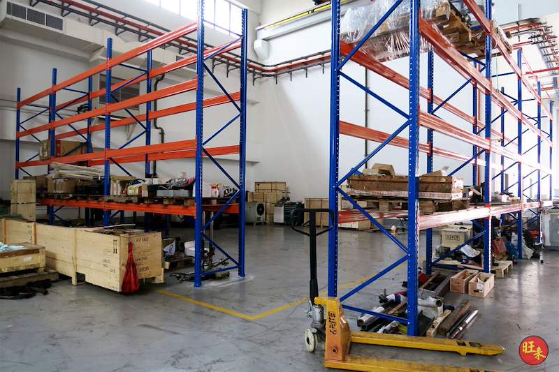 Two V3000 racking runs with a pallet truck and timber crates in the aisle between - V3000 Racking - V3-5 | Wong Lye Racking, Singapore Racking Manufacturer