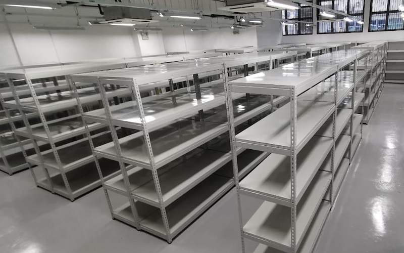 Long rows of grey boltless shelving with five levels, viewed along the aisle, shelves empty - Boltless Racking - B1 | Wong Lye Racking, Singapore Racking Manufacturer