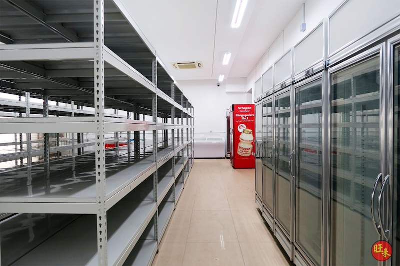 Boltless shelving rows beside glass-door chillers and a drinks fridge in the store - Boltless Racking - B5 | Wong Lye Racking, Singapore Racking Manufacturer