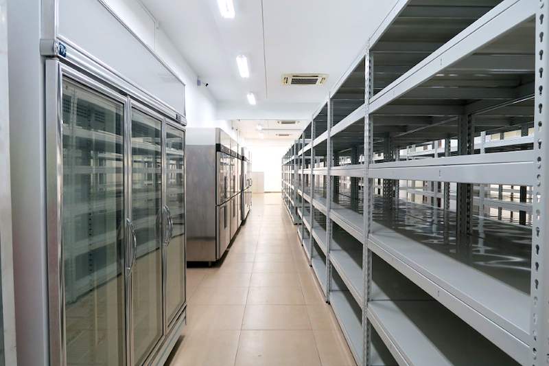 Boltless shelving rows opposite a line of glass-door chillers in the store - Boltless Racking - B5 | Wong Lye Racking, Singapore Racking Manufacturer