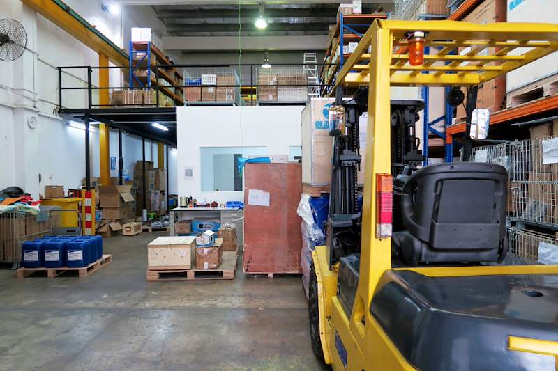 Forklift on the ground floor below the mezzanine, with racking on the deck above and palletised goods around - V5000 Racking - V5-8 | Wong Lye Racking, Singapore Racking Manufacturer