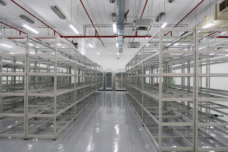 Central aisle between rows of beige boltless shelving, five levels each side - Boltless Racking - B7 | Wong Lye Racking, Singapore Racking Manufacturer