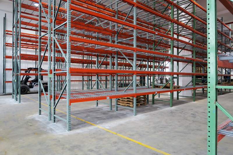 Pallet racking run with wire mesh decking on every level, forklift in the aisle beyond - V3000 Racking - V3-3 | Wong Lye Racking, Singapore Racking Manufacturer