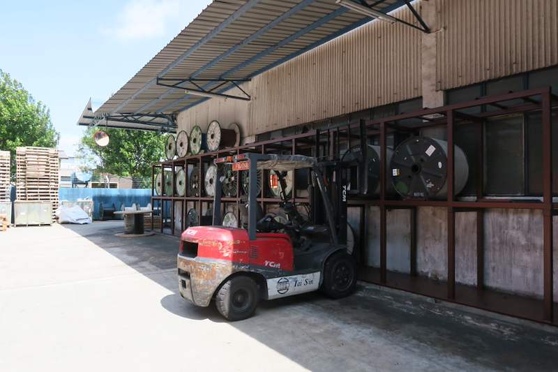 Cable-drum rack along the wall under the shed roof with a forklift parked in front - V5000 Racking - V5-1 | Wong Lye Racking, Singapore Racking Manufacturer