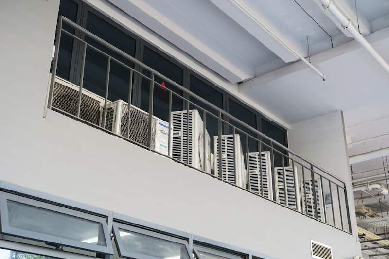 Row of air-conditioning condenser units on the high ledge behind a railing - Boltless Racking - B8 | Wong Lye Racking, Singapore Racking Manufacturer