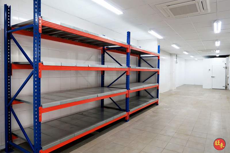 Long-span racking bays with blue uprights, orange beams and steel decking against the tiled wall - Boltless Racking - B5 | Wong Lye Racking, Singapore Racking Manufacturer