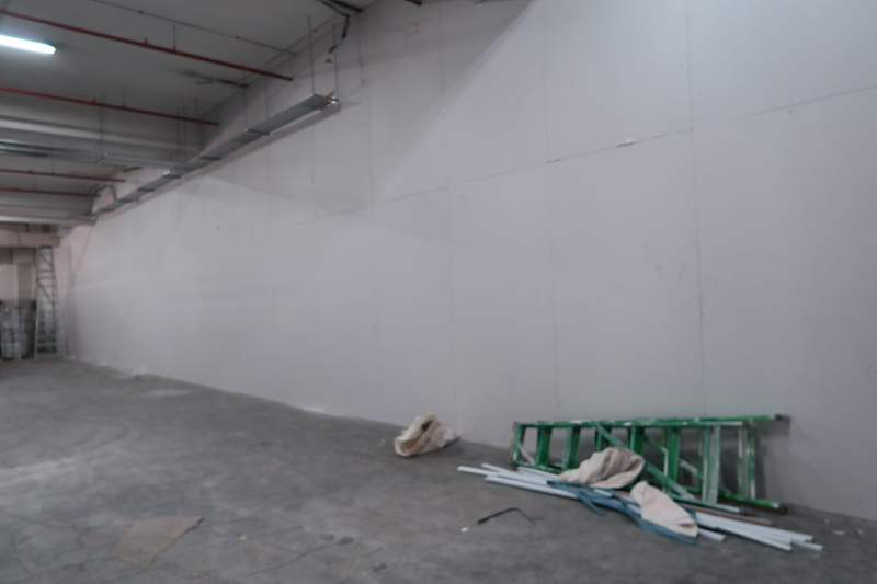 Before: bare corner of the unit with a ladder and offcuts on the concrete floor - Boltless Racking - B7 | Wong Lye Racking, Singapore Racking Manufacturer