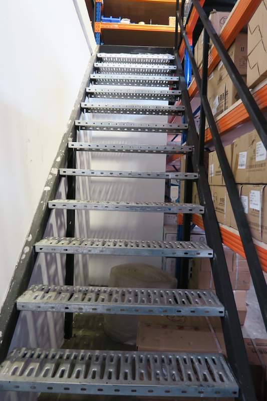 Steel staircase with perforated treads between racking bays loaded with cartons - V5000 Racking - V5-8 | Wong Lye Racking, Singapore Racking Manufacturer