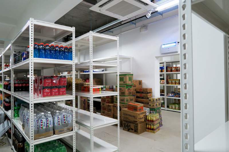 White boltless shelving units with bottled drinks on the shelves and cartons stacked beside - Boltless Racking - B6 | Wong Lye Racking, Singapore Racking Manufacturer