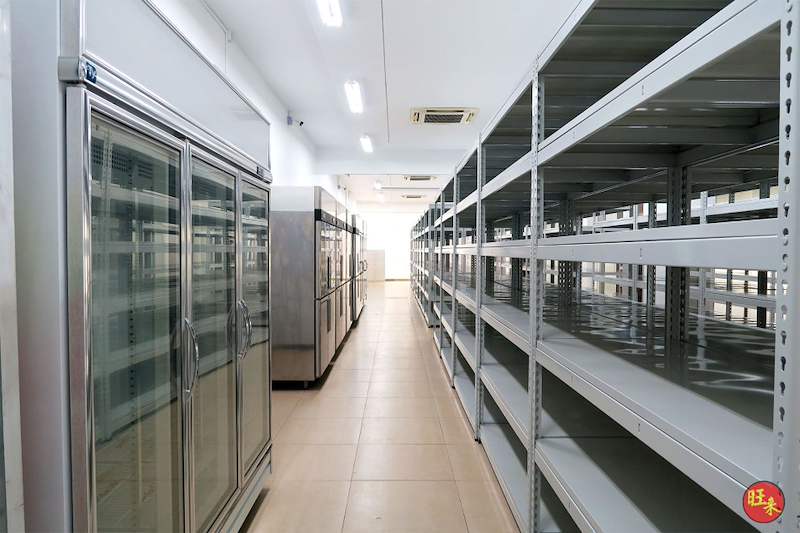 Boltless shelving rows facing a line of glass-door chillers - Boltless Racking - B5 | Wong Lye Racking, Singapore Racking Manufacturer