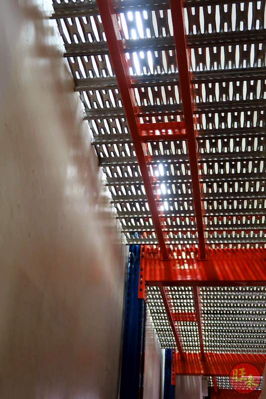 Underside of the mezzanine floor along a wall: perforated steel deck panels on red beams with blue uprights - V6000 Racking - V6-7 | Wong Lye Racking, Singapore Racking Manufacturer